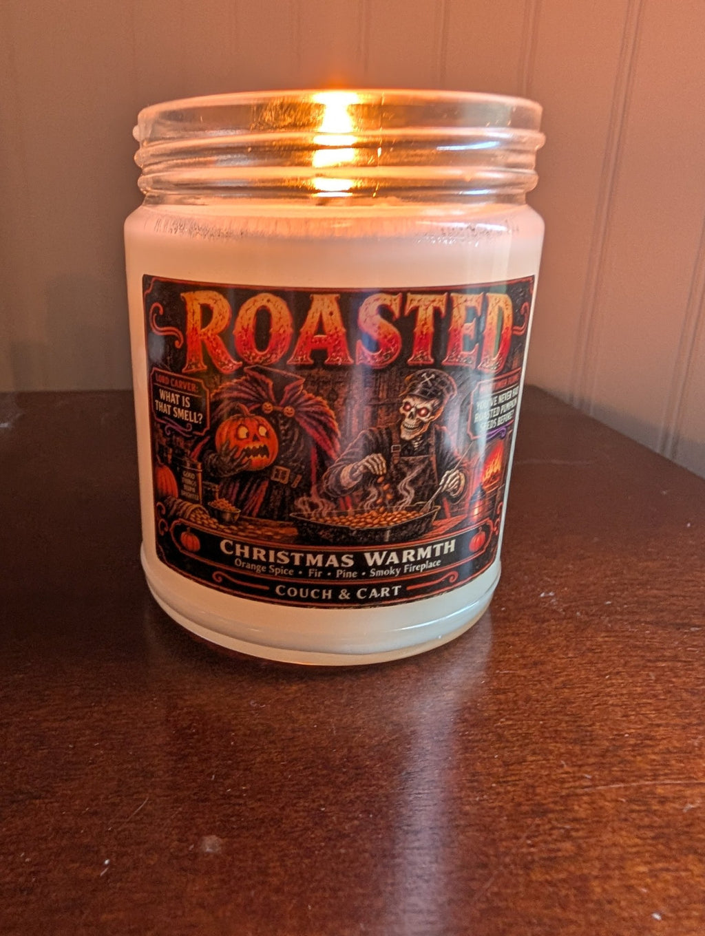 Real photo of the lit Roasted funny Christmas candle, Christmas Warmth scent with orange spice, fir and pine – Couch & Cart